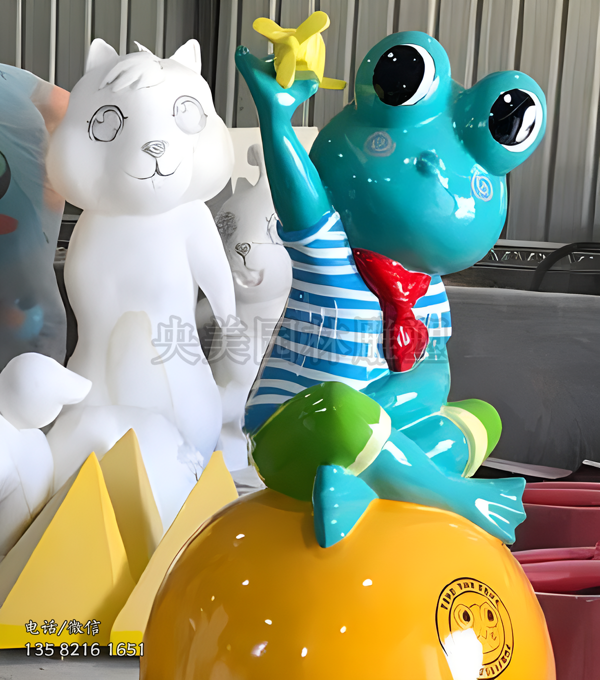 坐在球上放飛機(jī)的卡通青蛙雕塑